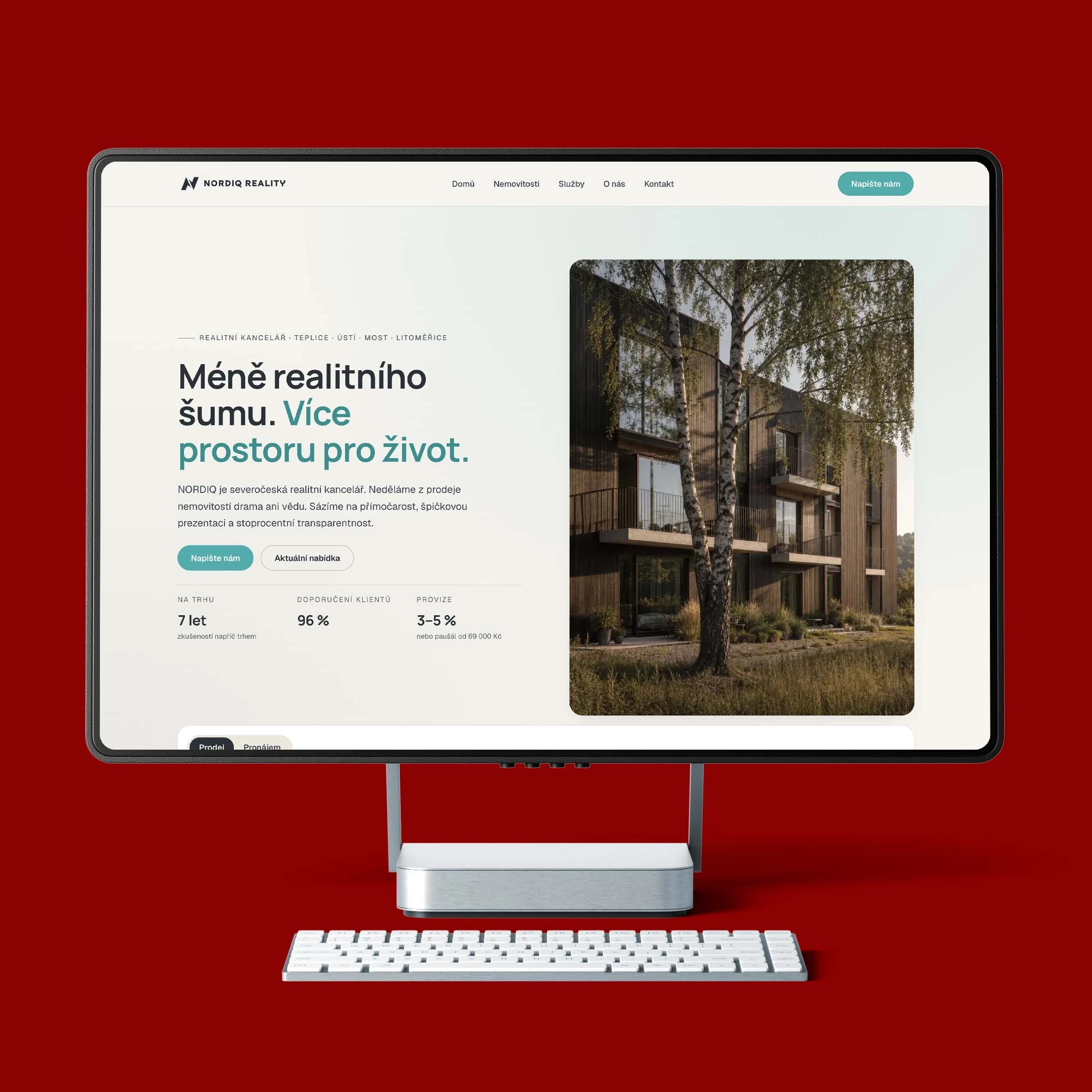 Úvodní stránka webu NORDIQ Reality na monitoru stolního počítače s hlavním sdělením a fotografií moderního domu