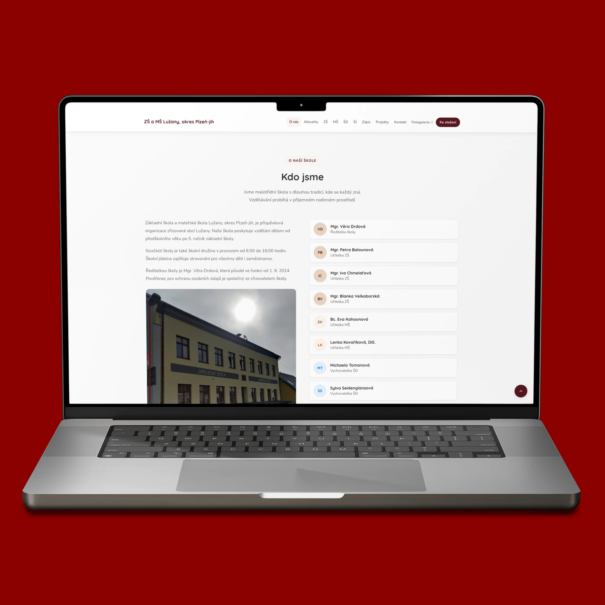 Sekce Kdo jsme na webu ZŠ a MŠ Lužany na MacBooku s fotografií budovy školy a seznamem pedagogů